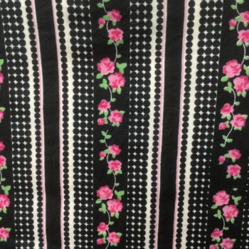 Tissu vintage à guirlande de fleurs roses sur bandes noires, encadrées par des bandes de rayures et de pois en noir et blanc.