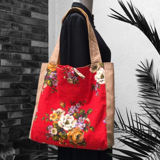 Sac cabas souple en tissu fleuri rouge avec poche intérieure plaquée et fermé par liens à nouer. Un tissu signé Agathe, création Beldecor, garanti air lumière lavable.