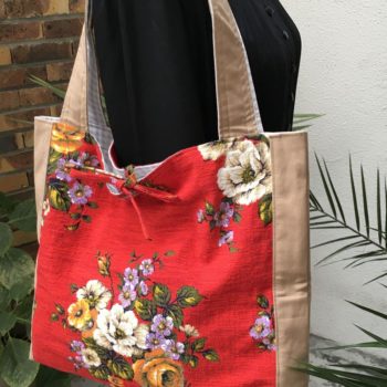 Grand sac cabas en tissu d'ameublement vintage revalorisé, porté épaule. Imprimé fleuri dans les tons mauves, blancs, beiges et oranges, feuillages verts. Création Beldecor, garanti air lumière lavable. Recto face A, détail.