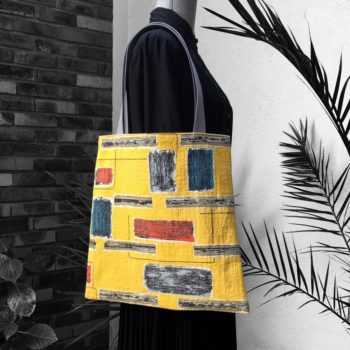 Tote bag design vintage, imprimé graphique, dessins en noir rouge bleu brun gris sur fond jaune moutarde.