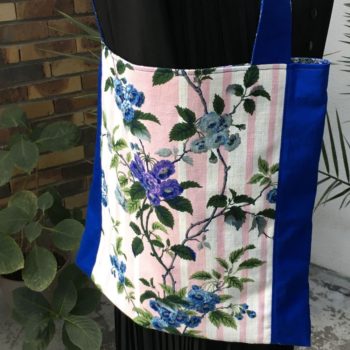 Sac en tissu de style bohème chic, Bazoches par Romanex de Boussac, dessin de Pascaline Villon, 1960s. Composition florale, branches fleuries, fleurs en bleu, gris, mauve, vert sur fond à larges rayures verticales en rose sur blanc. Recto face B.