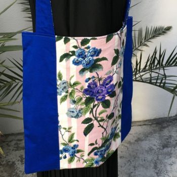 Sac en tissu de style bohème chic, Bazoches par Romanex de Boussac, dessin de Pascaline Villon, 1960s. Composition florale, branches fleuries, fleurs en bleu, gris, mauve, vert sur fond à larges rayures verticales en rose sur blanc. Recto face A.