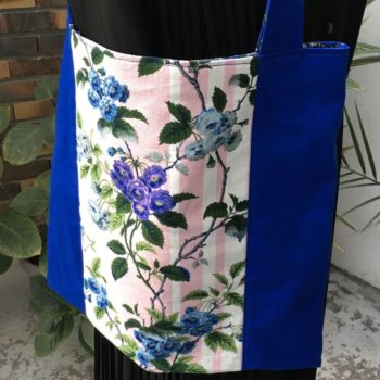 Sac en tissu de style bohème chic, Bazoches par Romanex de Boussac, dessin de Pascaline Villon, 1960s. Composition florale, branches fleuries, fleurs en bleu, gris, mauve, vert sur fond à larges rayures verticales en rose sur blanc. Recto face A.