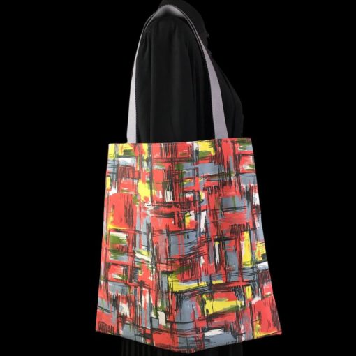 Totebag pour femme et pour homme, pièce unique de confection artisanale réalisée dans une toile d’ameublement vintage typique des années 1950s, imprimé de formes libres, motif abstrait multicolore en rouge, vert, bleu gris, jaune et blanc hachuré de traits noirs. Recto face B.