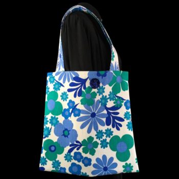 Totebag Flower Power, cabas Aubade, imprimé floral stylisé typique des swinging sixties, de grosses fleurs en bleu et vert sur fond blanc. Recto face A et bouton.