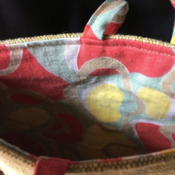 Sacoche en ceinture de kimono vintage. Au recto le sac présente une toile vintage en coton ou lin, au tissage rustique, un ancien obi japonais. Au verso la doublure est un fin tissu de coton à imprimé graphique, un motif de formes libres en jaune, rouge, vert, blanc et beige kaki.