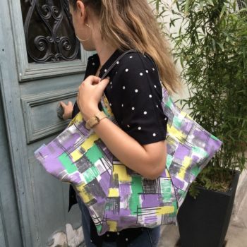 Cabas triangle en tissu vintage des années 1950s début 1960s, toile d’ameublement en coton. Imprimé graphique, motifs géométriques abstraits, formes libres. Vu porté, de profil.