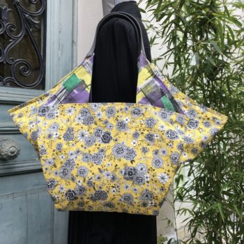 Cabas triangle en tissu vintage, doublure à motifs floraux dessinés de traits noirs et gris sur fond jaune.