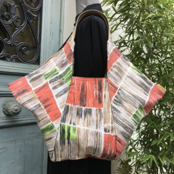 Sac origami cousu main, en tissu d'ameublement vintage revalorisé, imprimé de formes libres, motif abstrait multicolore en orange, vert, brun et beige, aplats de couleurs striés de noir, face A.