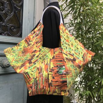 Sac origami en tissu vintage Marignan, imprimé de formes libres en orange, vert, brun et jaune, aplats de couleurs striés de noir, recto face A.