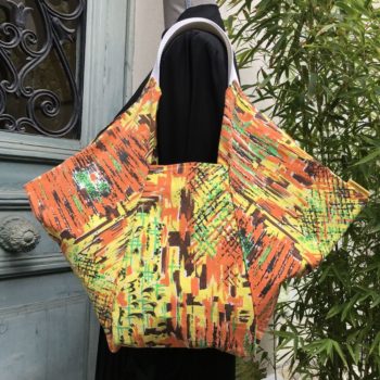 Sac origami en tissu vintage Marignan, imprimé de formes libres en orange, vert, brun et jaune, aplats de couleurs striés de noir, recto face B.
