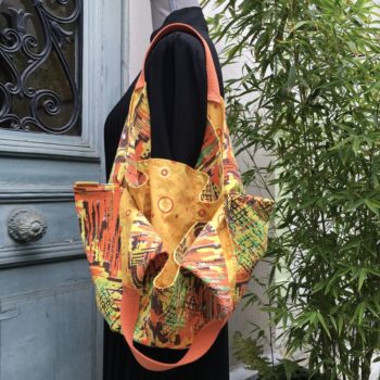 Sac souple en pliage origami de style japonais, en tissu vintage années 1950s doublé d'un imprimé de petits cercles en rouge, vert pâle, orange sur fond jaune, la doublure.