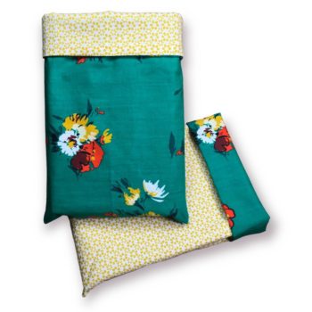 Housse à livre en tissu, à doublure de fleurs stylisées jaune moutarde, au recto imprimé de fleurs stylisées en ivoire, blanc, ocre jaune / jaune moutarde, rouge orangé et bordeaux sur fond vert turquoise.