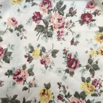 Tissu fleuri liberty, imprimé de petites fleurs en rose, jaune et vert sauge sur fond ivoire.