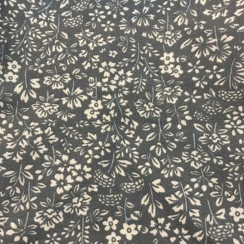 Imprimé Flanelle de l'éditeur Safeco, fleurs stylisées blanc cassé / beige sur fond uni vert sauge.