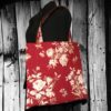 Grand totebag rouge bordeaux, en toile vintage. Cabas de forme carrée, doublé réversible, pour femme ou pour homme. Composition florale de type grisaille, grandes fleurs et branches de rosiers en blanc cassé / écru et beige sur fond rouge bordeaux. Recto face A.