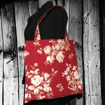 Grand totebag rouge bordeaux, en toile vintage. Cabas de forme carrée, doublé réversible, pour femme ou pour homme. Composition florale de type grisaille, grandes fleurs et branches de rosiers en blanc cassé / écru et beige sur fond rouge bordeaux. Recto face A.