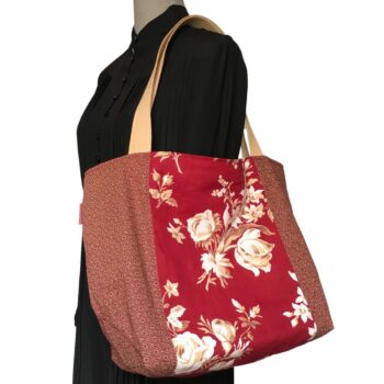 Sac cabas XL rouge bordeaux. Composition florale de type grisaille, grandes fleurs et branches de rosiers en blanc cassé / écru et beige sur fond rouge bordeaux. Bordée au recto du même tissu que la doublure. Recto face A.