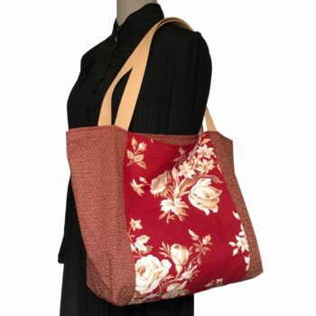 Sac cabas XL rouge bordeaux. Composition florale de type grisaille, grandes fleurs et branches de rosiers en blanc cassé / écru et beige sur fond rouge bordeaux. Bordée au recto du même tissu que la doublure. Recto face B.