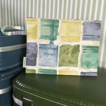 Trousse zippée, pochette pour femme, en toile d'ameublement vintage en coton, à imprimé de formes libres en vert, bleu, jaune, sur fond blanc cassé / écru.