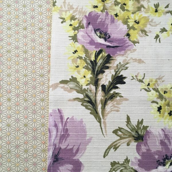 Toile d’ameublement vintage de la période 1940s 1950s, en coton. L’imprimé floral et champêtre déploie un dessin de pivoines en mauve et lilas, et de petites fleurs des champs jaunes (de type renoncule des prés). Le tissu, en coton épais, a une texture de fines rainures horizontales de type ottoman.