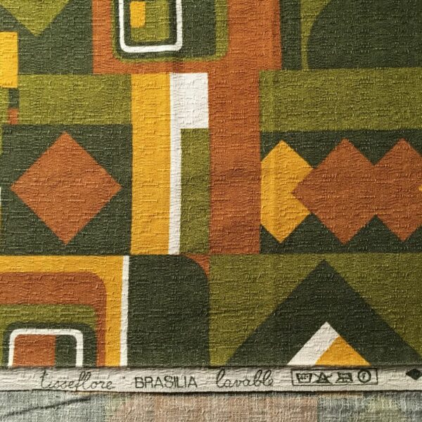 Toile d’ameublement vintage en coton texturé (barkcloth). L’imprimé graphique présente une composition de formes géométriques en jaune maïs, vert olive, jaune curry, brun orangé et blanc.