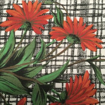 Toile d’ameublement vintage des années 1960s, en coton. Le dessin montre un bouquet de quatre marguerites rouges sur fond blanc strié et quadrillé de noir.