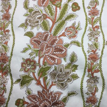 Toile de coton de type chintz, à effet satiné et soyeux, au toucher légèrement glacé. L’imprimé fleuri baroque forme des frises de fleurs et branches en rouge beige, rouge orangé, vert olive et vert pâle, sur fond uni blanc crème.