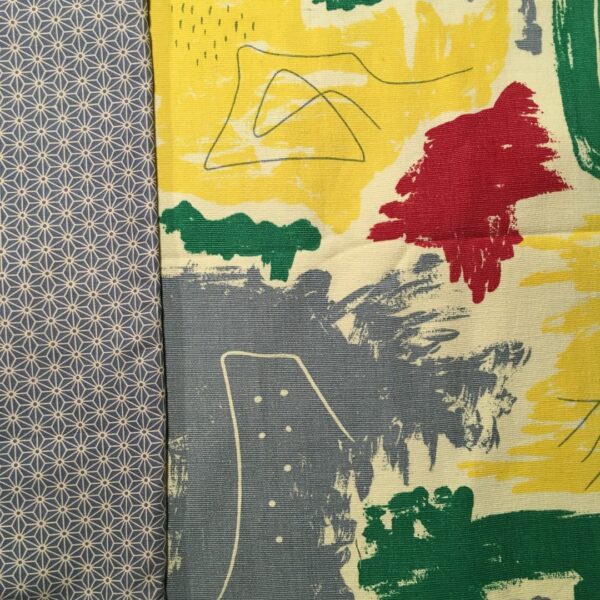 Toile d’ameublement vintage des années 1950s. L’imprimé graphique montre des formes libres en couleurs franches, jaune, vert, rouge, bleu, avec effets de crayonné, sur fond jaune pâle ou blanc crème ivoire. Et en doublure une popeline de coton imprimée d’un motif traditionnel japonais asanoha (étoile, feuille de chanvre ou de lin).