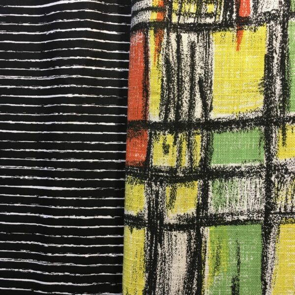 Toile d’ameublement vintage en coton texturé (barkcloth). L’imprimé graphique présente un quadrillage de formes géométriques en vert vif, jaune, orange, striées de noir, sur fond blanc. Et en doublure une popeline de coton imprimée de rayures horizontales irrégulières en blanc sur fond noir.