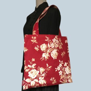 Grand totebag rouge bordeaux, en toile vintage. Cabas de forme carrée, doublé réversible, pour femme ou pour homme. Composition florale de type grisaille, grandes fleurs et branches de rosiers en blanc cassé / écru et beige sur fond rouge bordeaux. Recto face B, exemplaire 3.